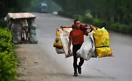 Складання равлика людина з Китаю, яка зношує будинок на спині